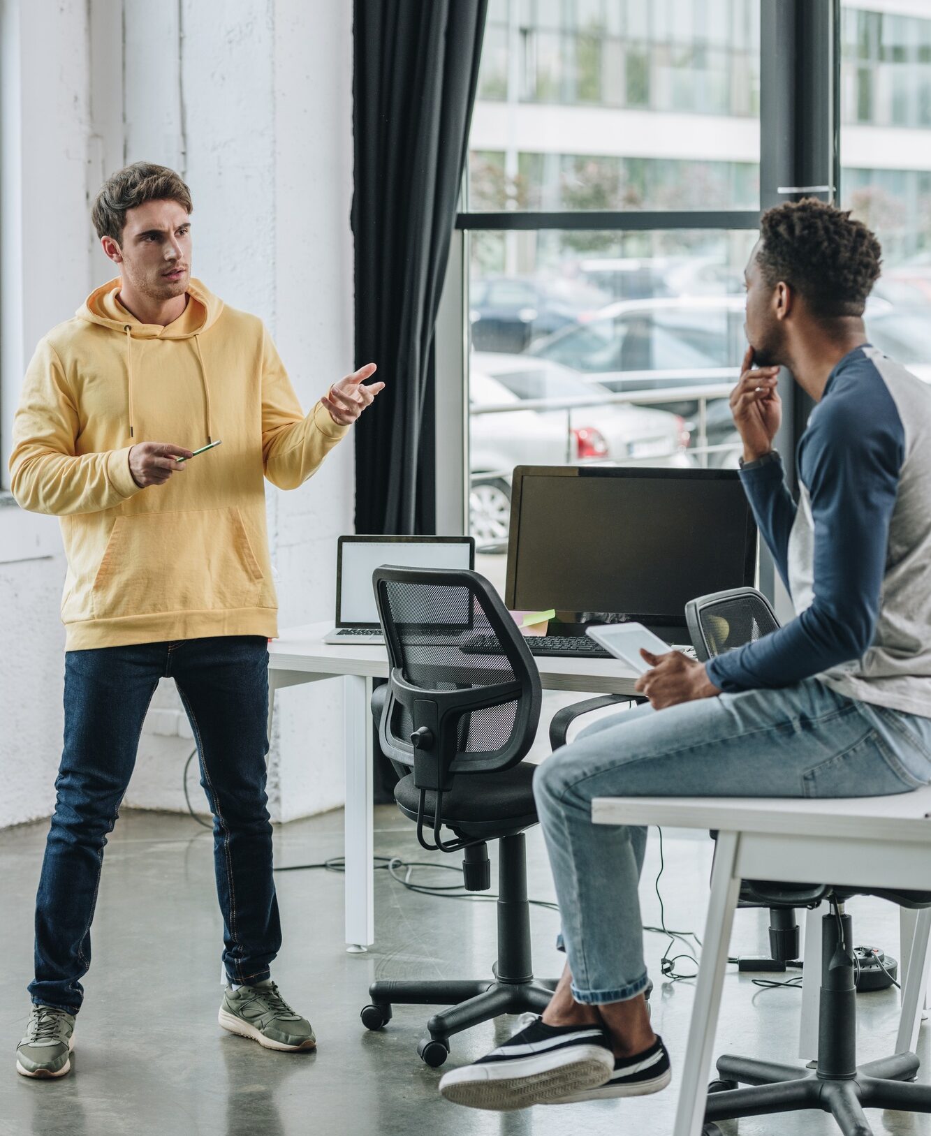 two multicultural programmers discussing ideas in office